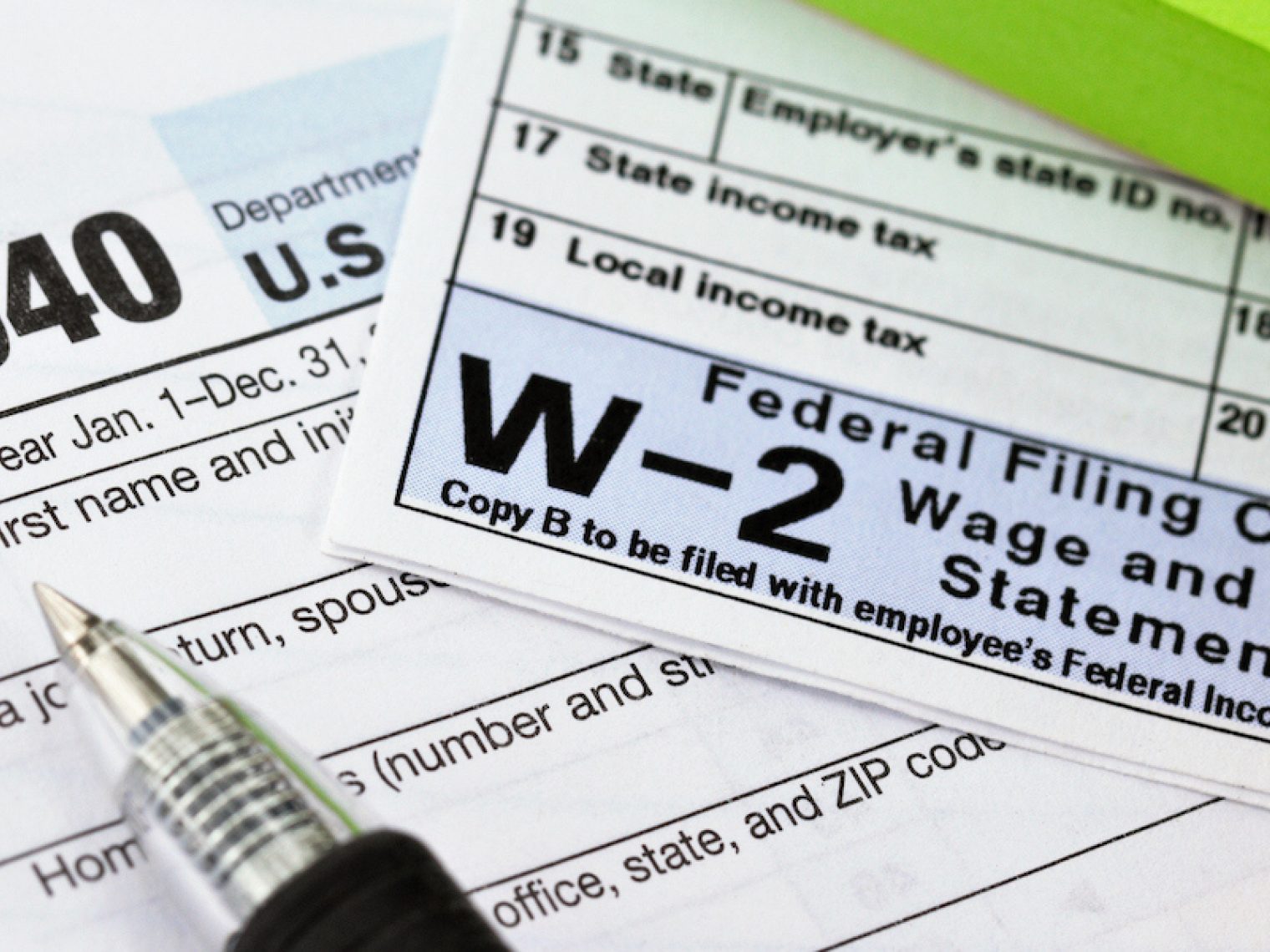 A picture of W2 tax form with a pen.