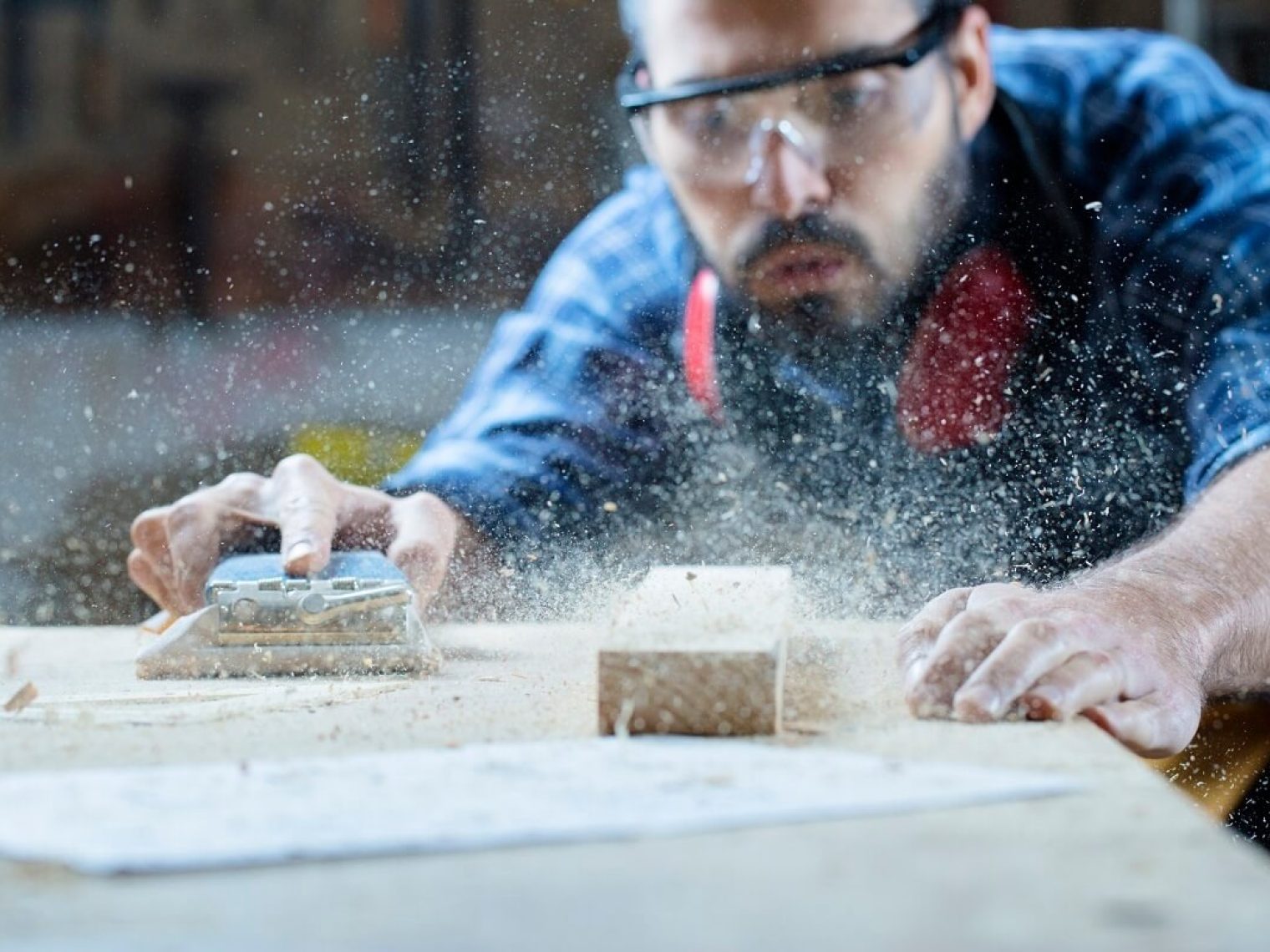 A home contractor sanding a piece of wood.