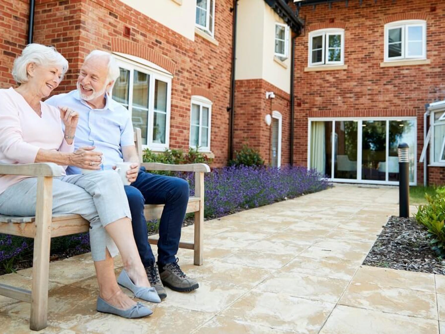 Older couple sit in garden at an age restricted community.