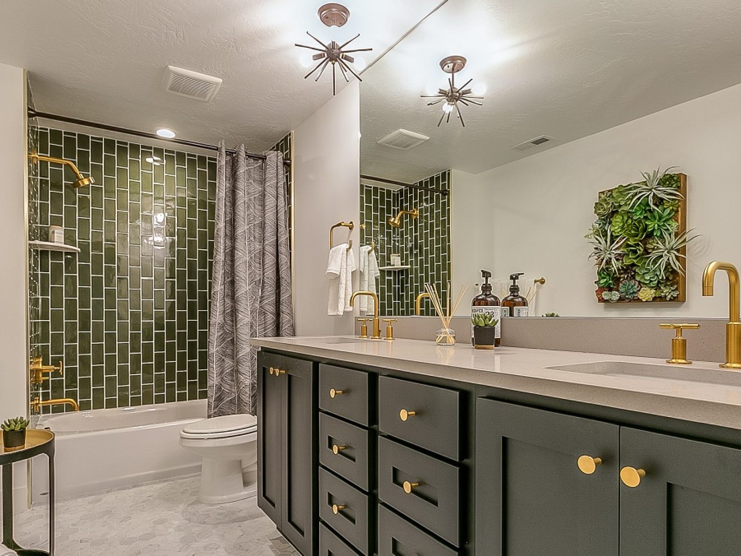 A very nice master bathroom with green and gold accents.