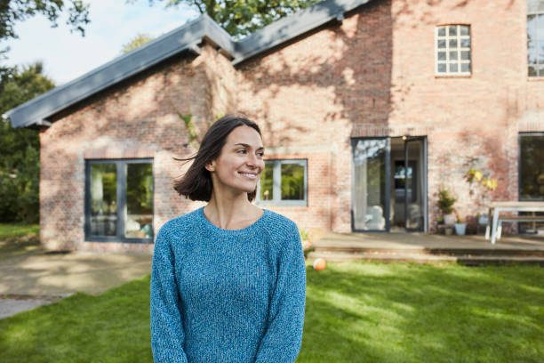 Woman in front of brick house